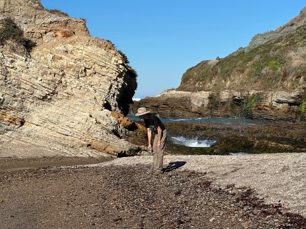 Daniel looking at rocks on Spooner Beach at Montaña de Oro State Park in Los Osos, California. Picture by Happy Vegan Campers.