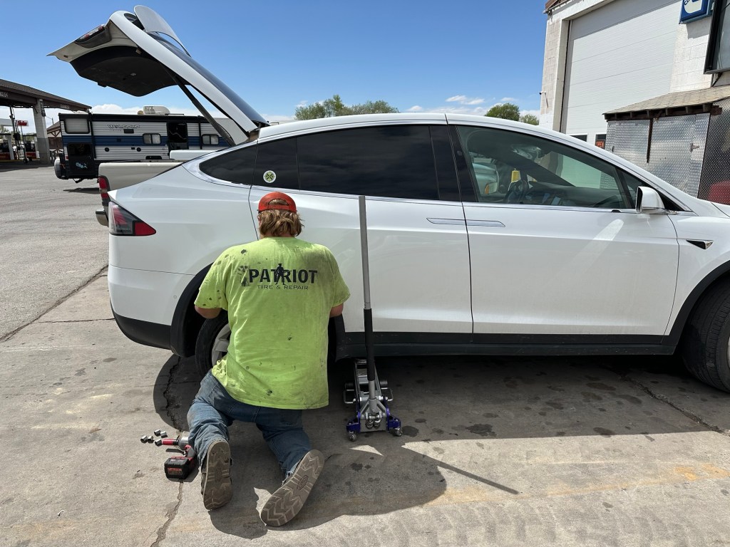 Tire leak being fixed on Tesla. Picture by Happy Vegan Campers.