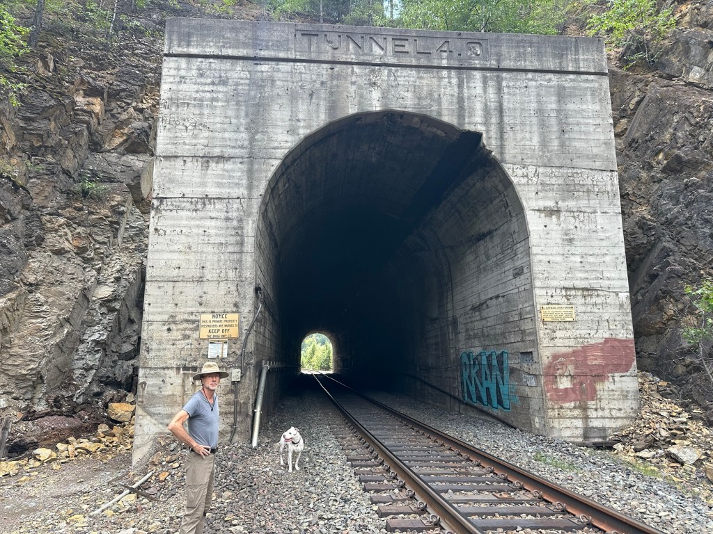 Daniel and Peter by train tracks tunnel near Glacier National Park in Montana. Picture by Happy Vegan Campers.