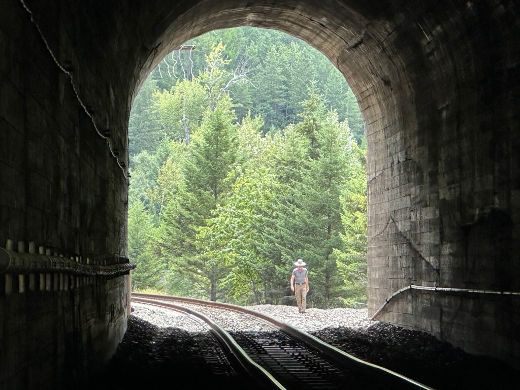 Daniel and train tracks tunnel near Glacier National Park in Montana. Picture by Happy Vegan Campers.