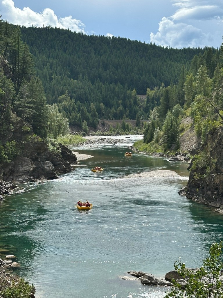 People on rafts on river near Glacier National Park in Montana. Picture by Happy Vegan Campers.