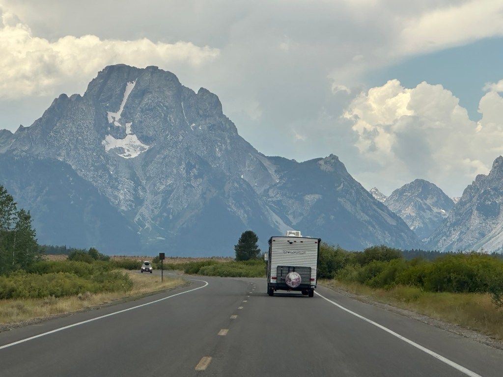 Happy Vegan Campers driving on road in Grand Teton National Park in Wyoming, USA.