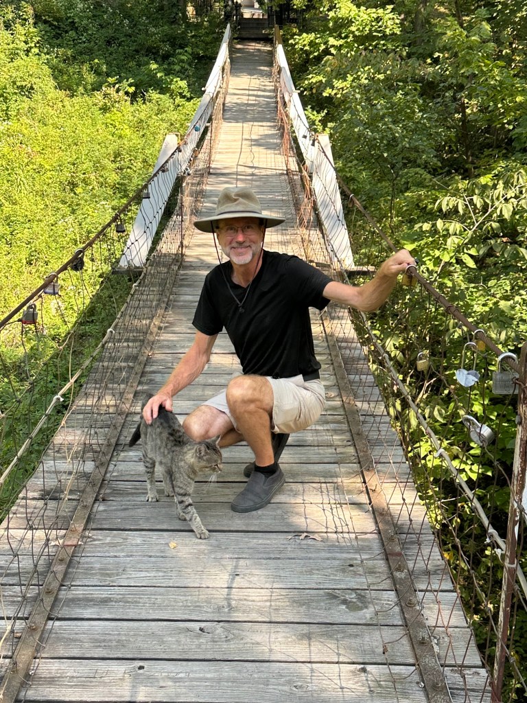 Daniel and friendly cat on Lover’s Leap Bridge in Columbus Junction, Iowa, USA.