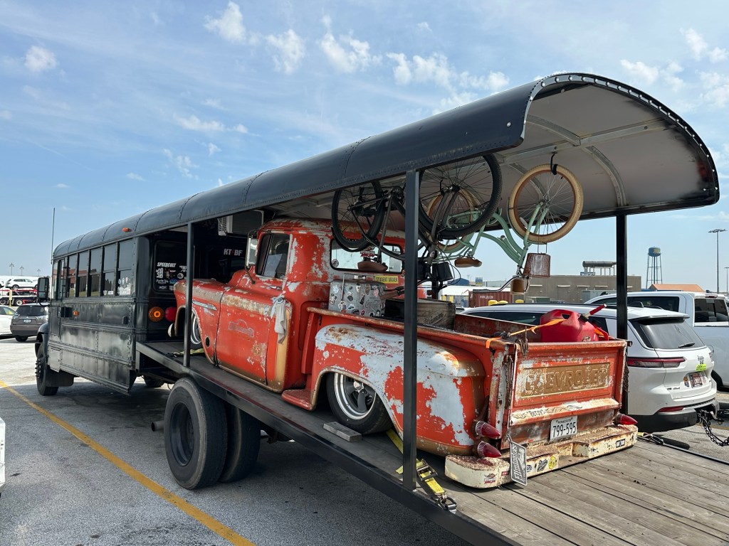 School bus conversion with garage holding vintage truck.